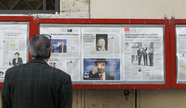 man looking at news billboard